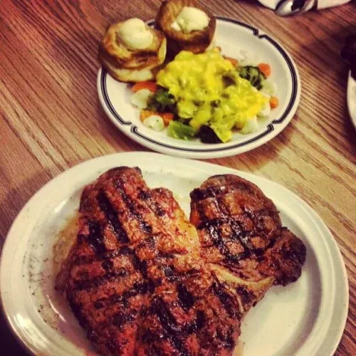 Two charcoal-grilled steaks with a side salad
